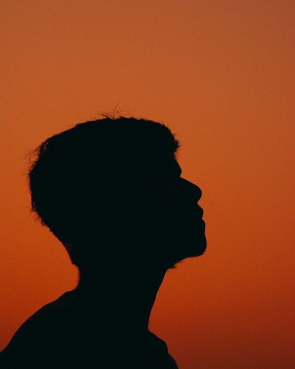 Silhouette of a person meditating against a warm, glowing background.